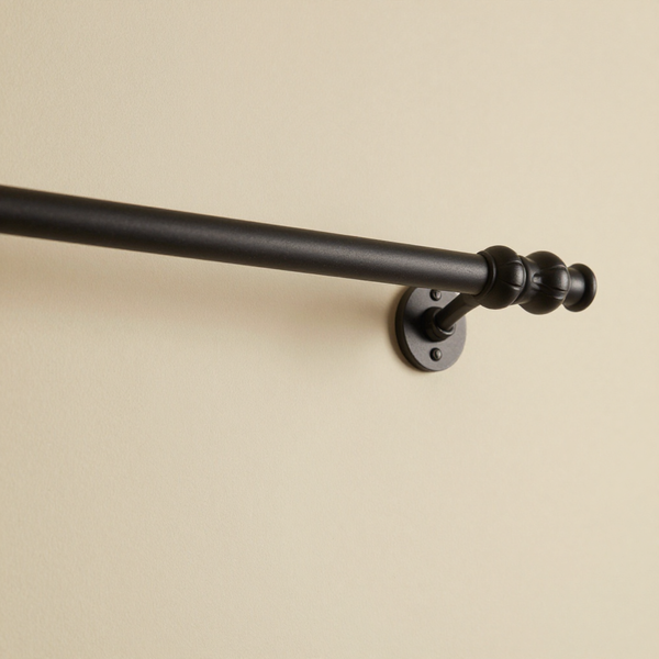 Matte black curtain rod with finials and brackets
